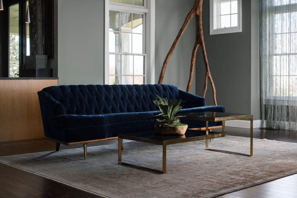 Elegant living room with a navy velvet sofa and gold-accented coffee table.