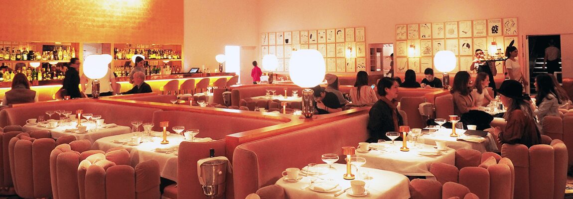 Cozy restaurant interior with warm lighting and pink booths.