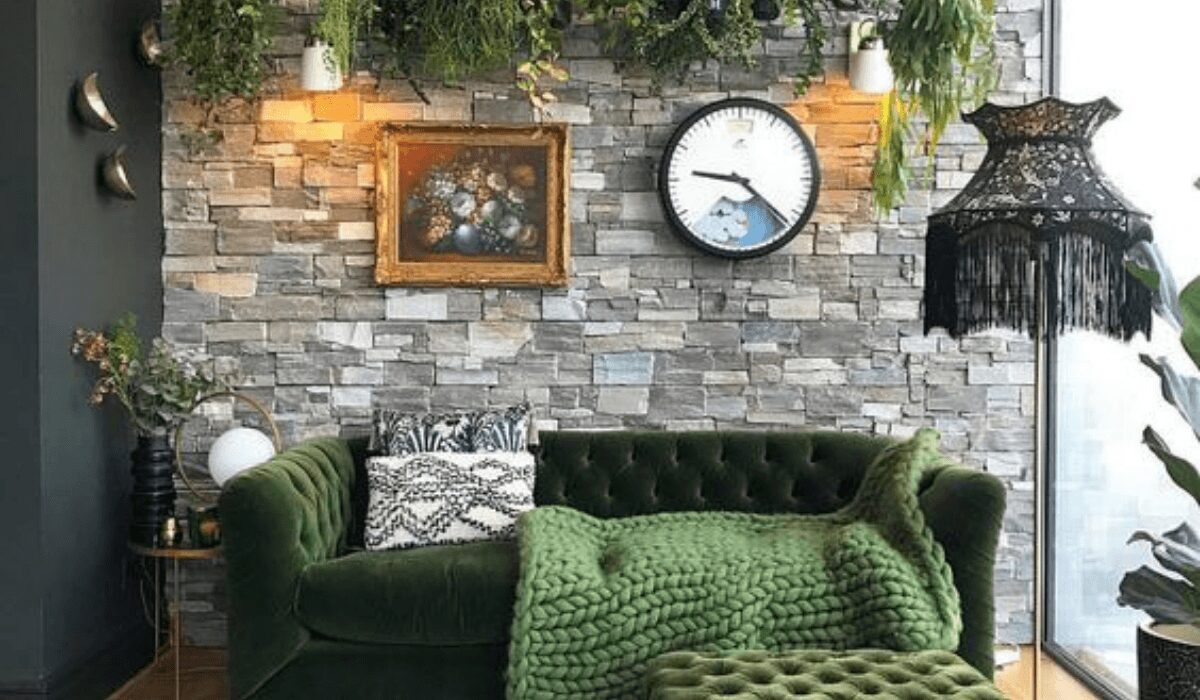 Cozy living room with green velvet sofa and rustic wall decor.